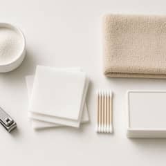 A cockatiel perched beside a small first aid kit with styptic powder, nail clippers, and a folded hand towel laid out on a table